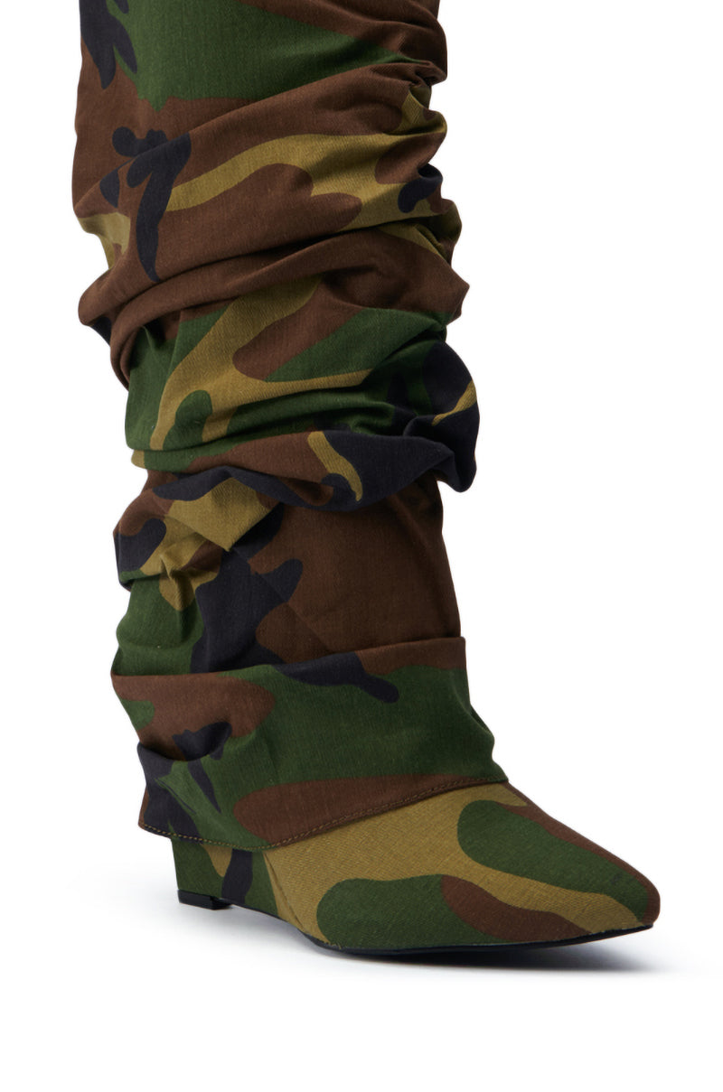Close-up of the AZALEA WANG ZUMMA CAMO WEDGE BOOT, a slouchy knee-high with a green, brown, and black camouflage pattern, featuring a pointed toe and low heel.