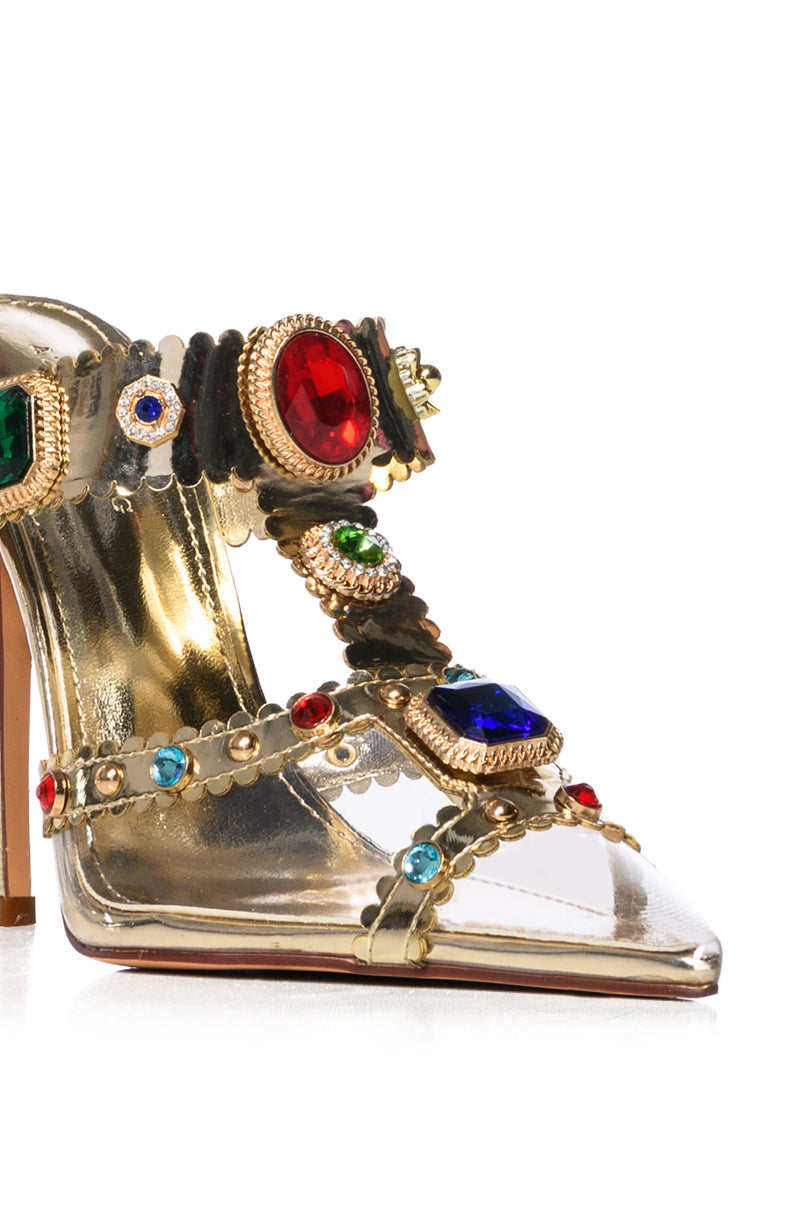 The AZALEA WANG ZYA Multi Gold Embellished PVC Pump features a golden high-heel design with a pointed toe, adorned with colorful gemstones and intricate studded detailing on the straps. Its sleek stiletto heel boasts a metallic finish for added elegance.