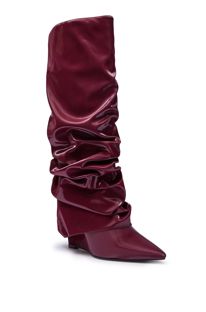 The AZALEA WANG ZYLLA Burgundy Patent Wedge Ruched Boot features a tall, shiny burgundy patent finish, pointed toe, wedge heel, and bold ruched slouch detailing along the shaft.