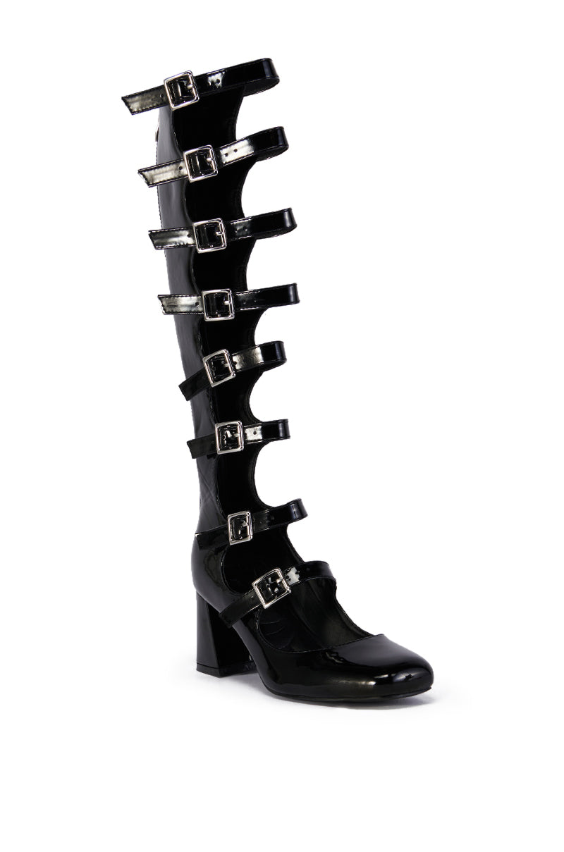 The AZALEA WANG LAIMA BLACK BOOT is a shiny black patent knee-high boot with seven silver buckle straps up the front, crafted from faux leather and set on a chunky mid-height heel.