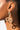 Close-up profile view of a person wearing the BIG TIMER SNAKE EARRING. This gold earring features a detailed snake design, with the head positioned near the earlobe and the body forming an elegant coil. The plain white background accentuates the intricate details of this exquisite piece.