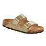 The BIRKENSTOCK ARIZONA BF GOLD features two adjustable buckle straps over the foot, a cork footbed, and a black rubber sole. The tan-colored sandal is positioned at an angle, facing slightly to the left.