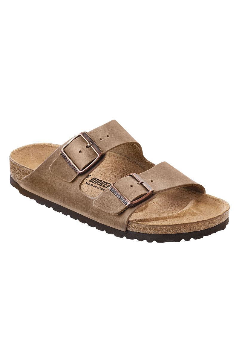 A single SEXY CASUAL FLAT taupe sandal featuring adjustable leather straps with metal buckles, a contoured cork-latex footbed, and a black EVA sole.