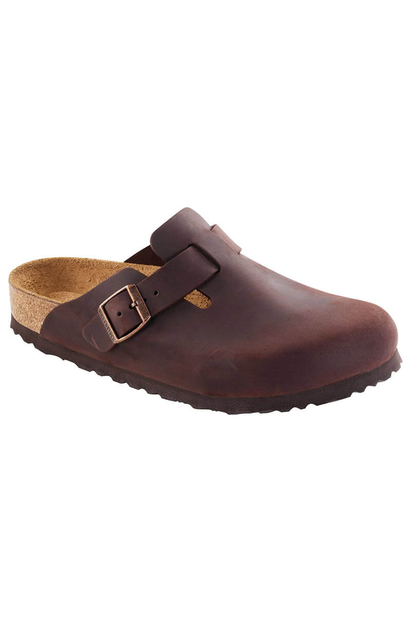 Introducing the SEXY CASUAL SLIP ON: a single brown leather clog with a closed toe and an adjustable buckle strap. This shoe features a cork and rubber sole, offering an exceptional blend of comfort and durability.
