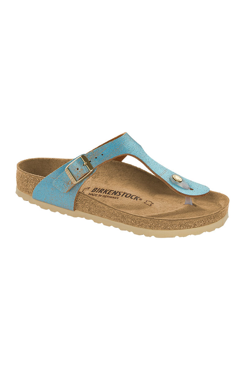 A single SEXY CASUAL FLAT Birkenstock sandal in blue, featuring a T-strap design with an adjustable metallic buckle on the side. The footbed is crafted from cork and covered with soft brown suede material. The outsole is light beige and sports a textured pattern for enhanced traction.