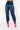 Against a white background, a person is posing in the BODY PARTY JOGGER, which are shiny dark blue high-waisted pants that cinch at the ankles. They are also wearing bright pink high-heeled shoes with ankle straps. Only the lower half of their body is visible.