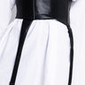 A person is wearing a white button-up shirt that is cinched at the waist with the DON'T CROSS ME FAUX LEATHER CORSET. The corset features two adjustable straps hanging down, each with a metal clip attached at the ends.