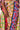 Close-up of a person wearing the SEXY FLORAL MAXI SKIRT, which showcases vibrant patterns in yellow, blue, red, and orange backgrounds with diverse floral designs. The person's hand rests on the skirt near a high slit.