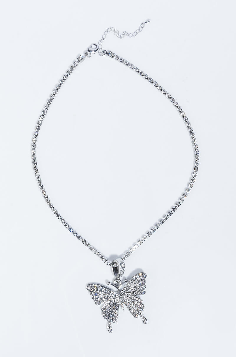 Presenting the FLY GIRL BLING BUTTERFLY NECKLACE: a delicate piece featuring a butterfly pendant encrusted with sparkling stones. The fine chain is adorned with small, equally spaced stones and includes a custom clasp and extender chain at the top for an adjustable length.