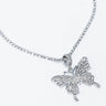 The FLY GIRL BLING BUTTERFLY NECKLACE showcases a butterfly-shaped pendant encrusted with sparkling gems. The pendant is elegantly suspended from a string of small, shimmering beads, giving it an elegant and delicate look. A plain, light-colored background accentuates the intricate details of the necklace.