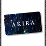 Displayed against a backdrop of blue and white sparkling lights, the AKIRA Gift Card features rounded corners and is presented at a slight angle. Its border displays the repeated text "THE PERFECT GIFT." Redeemable online for a seamless experience, this card embodies the signature style of the AKIRA brand.