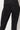 A close-up image shows a person wearing the NEW YORK SHINY LEGGING PANTS. The black fabric has a sparkly finish, reflecting light to create a shimmering effect. These high-waisted leggings emphasize their form-fitting appearance.