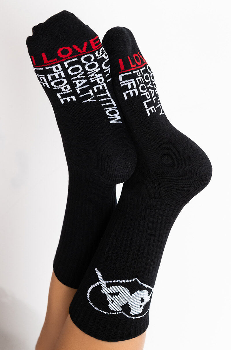A pair of the KAPPA ENDLESS LOVE ANKLE SOCKS in black featuring white and red text. One sock displays "I LOVE SPORTS," "COMPETITION," "LOYALTY," and "PEOPLE," while the other reads "I LOVE LOYALTY," "PEOPLE," "LIFE," and "SPORTS." Both socks include a white graphic of sunglasses near the toe. 1