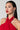 A woman with straight hair wearing a red halter neck dress and long, dangling KISS ME YOU FOOL DANGLE EARRINGS. She has red lipstick and is gazing slightly off to the side against a plain gray background.