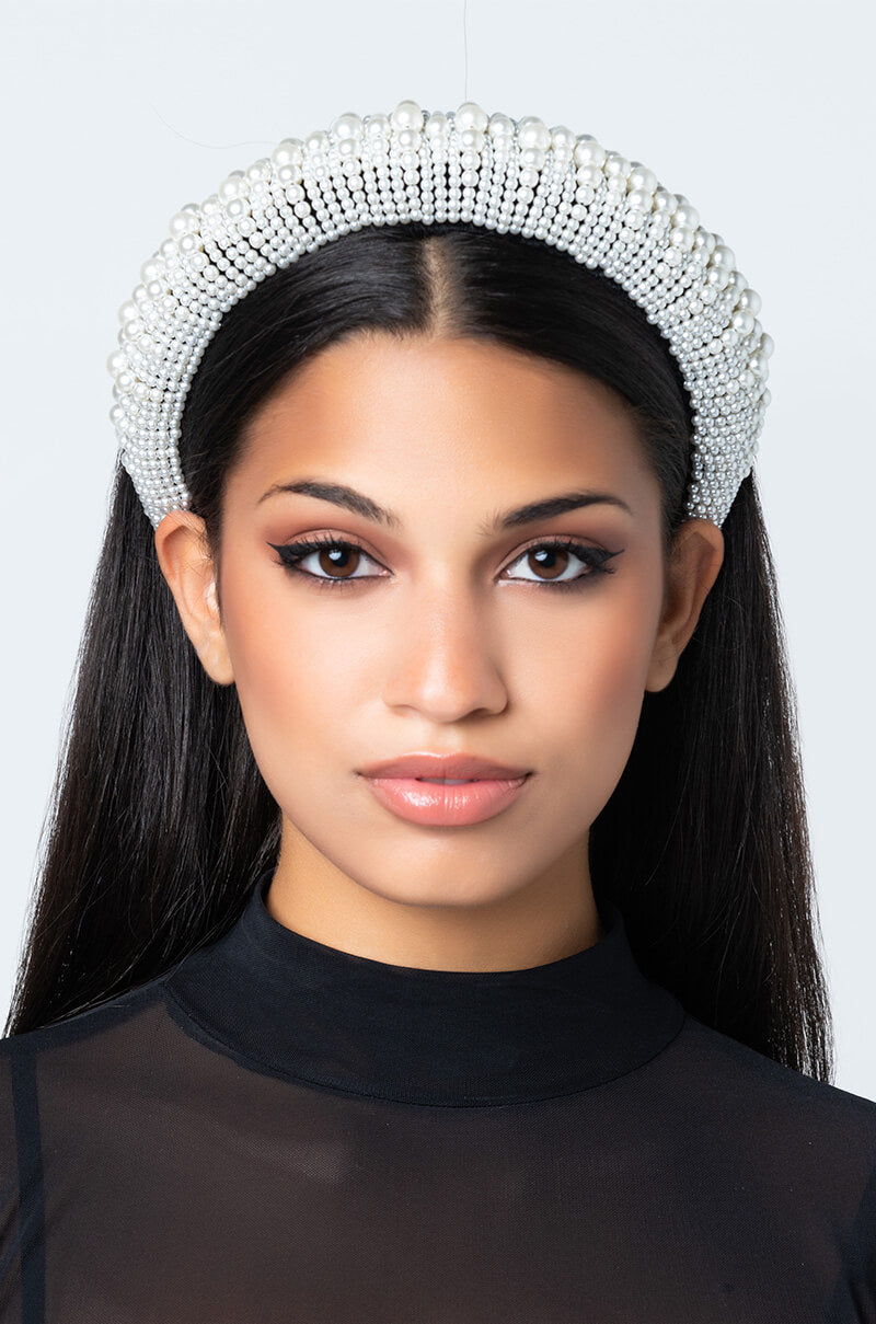 A woman with long, straight black hair wears the elegant LET ME UPGRADE YOU HEADBAND. She has a neutral expression and is dressed in a black, sheer top against a plain white background.