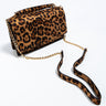 Introducing the LOOKIN GOOD LEOPARD BAG, a chic shoulder accessory featuring a trendy leopard print, an elegant gold chain strap, and a convenient flap closure. Displayed on a minimalistic white background, the partially extended strap beautifully showcases its length and intricate details.