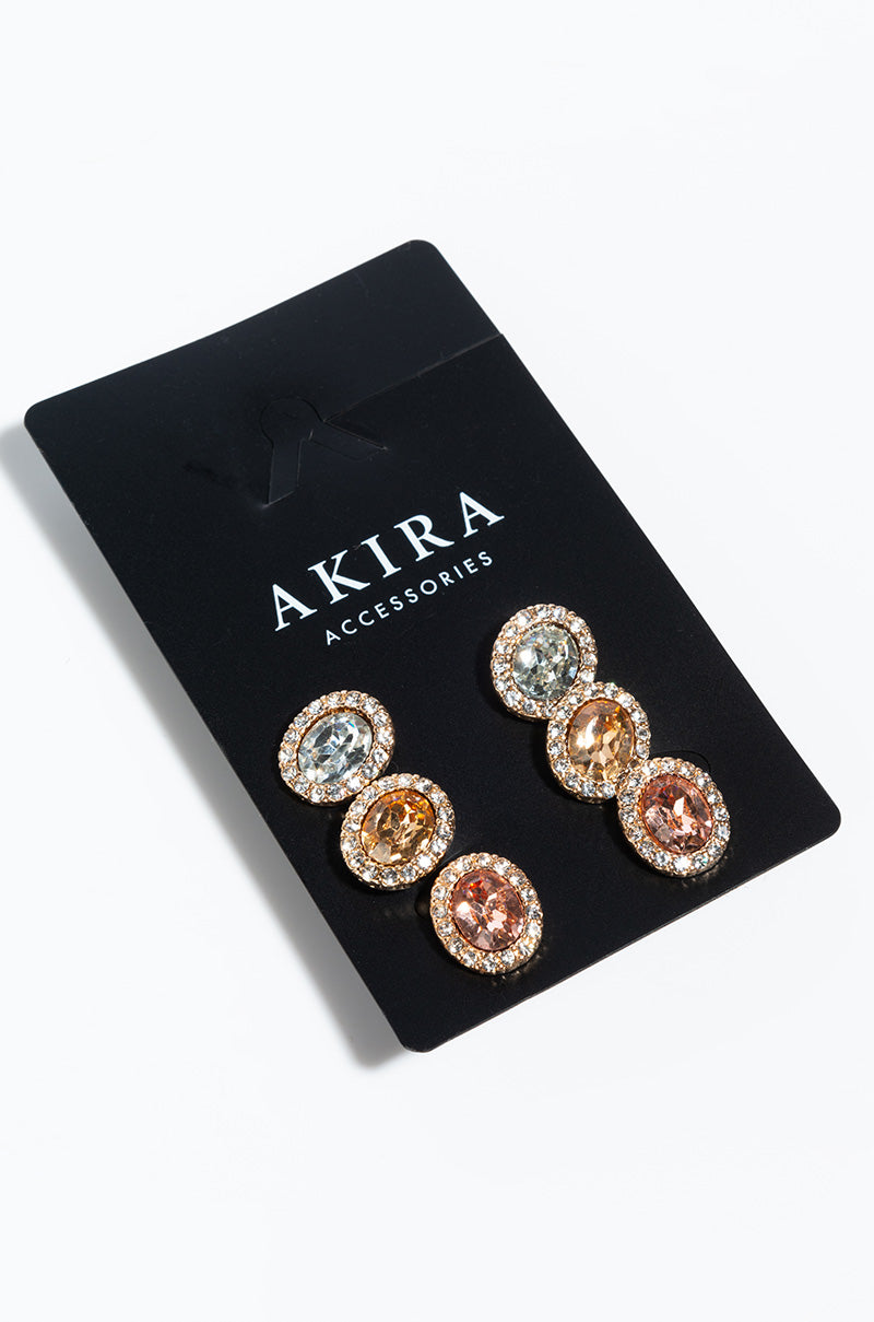 A black card labeled "Marie Antie Stud Pack" showcasing three pairs of earrings. Each pair highlights a large central gemstone in different colors: amber, blue, and pink, encircled by small clear stones.