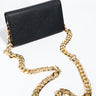 The PURSE, a sophisticated black leather clutch featuring a long, thick gold chain strap, is showcased against a white background. Its sleek and minimalistic design makes it the ideal accessory for an elegant night out.