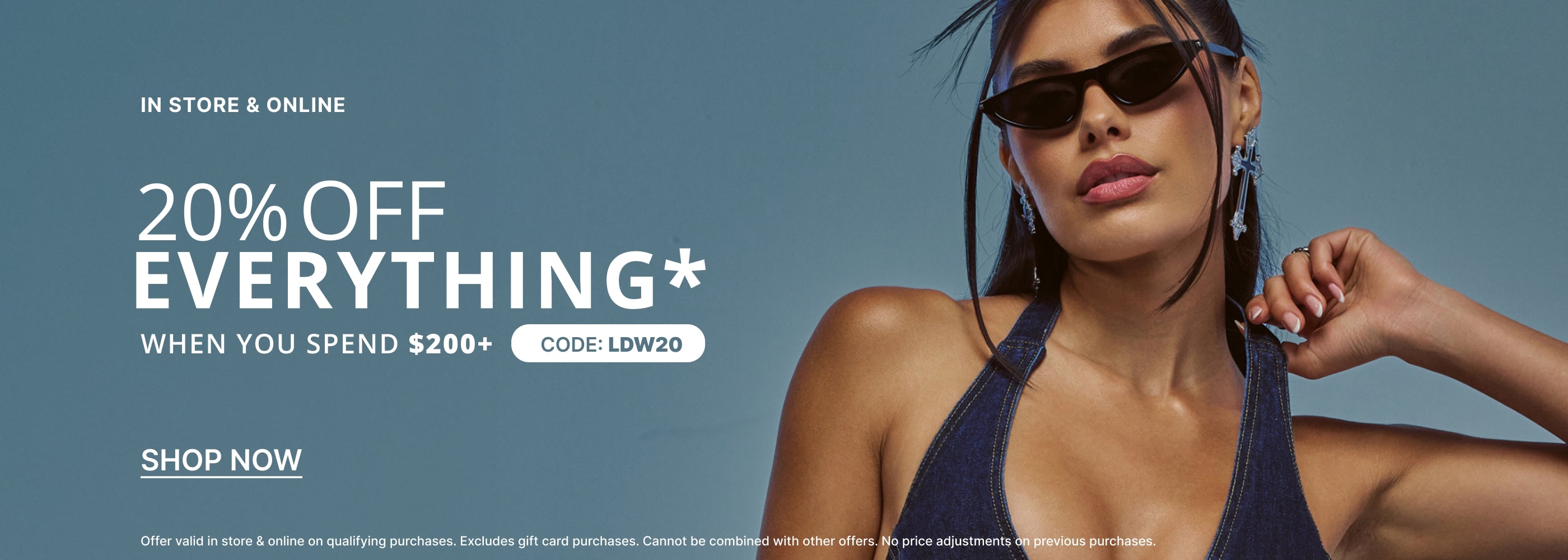 Promotional banner featuring a woman wearing dark sunglasses and a navy bikini top against a blue-gray background, with large text reading '20% OFF EVERYTHING WHEN YOU SPEND $200+' and 'SHOP NOW'.