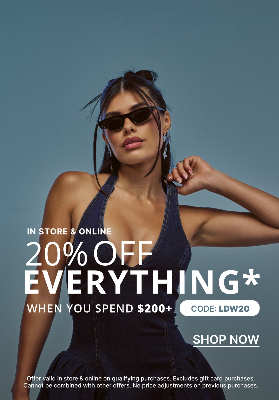 A promotional fashion ad featuring a woman wearing dark sunglasses and a dark halter dress against a muted blue-gray background, with large text reading '20% OFF EVERYTHING WHEN YOU SPEND $200+' and 'SHOP NOW'.
