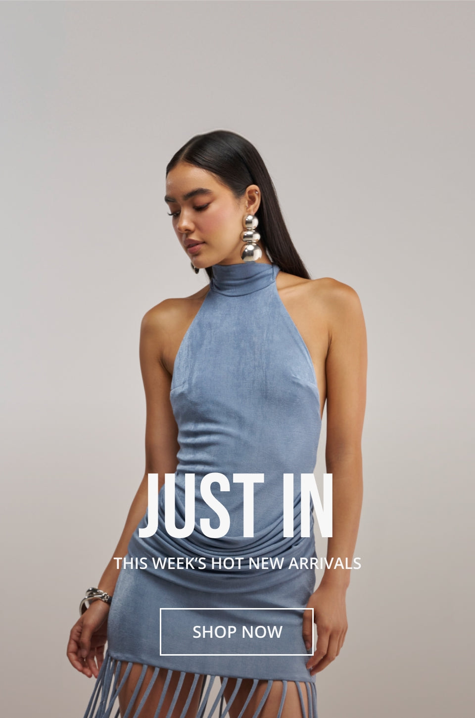 A model wearing a light blue high-neck sleeveless dress with fringe detailing at the hem, posed against a neutral gray studio background with promotional text overlay.