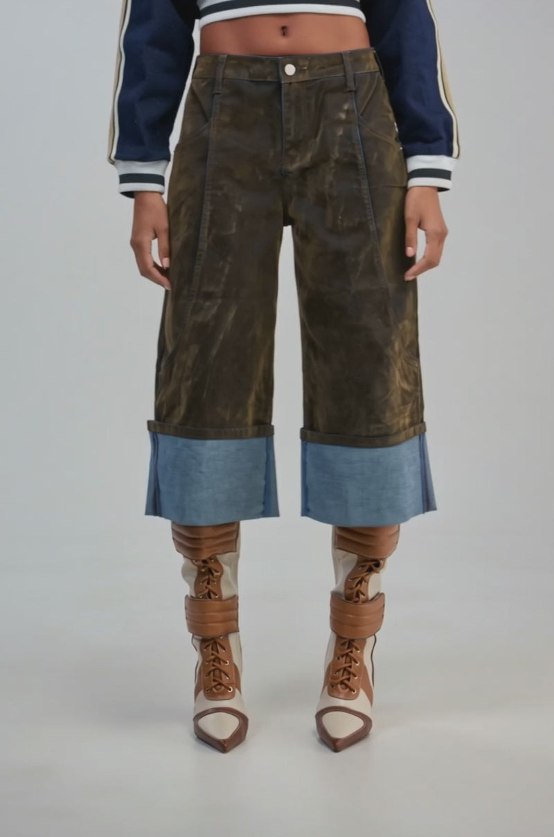 Video of a woman modeling the FALL VIBES VELVET BERMUDA SHORT—dark brown velvet bermuda shorts featuring wide, light-blue denim cuffs.