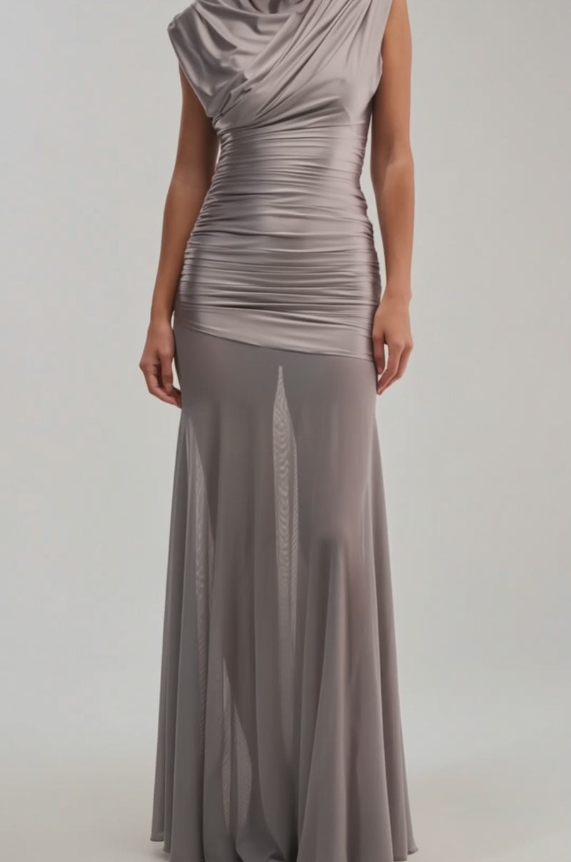 Video of woman modeling the LIMITLESS SATIN MAXI DRESS, a floor-length taupe gown with ruched details, draped sleeves, and a sheer flared skirt. Fitted at the bodice and hips.