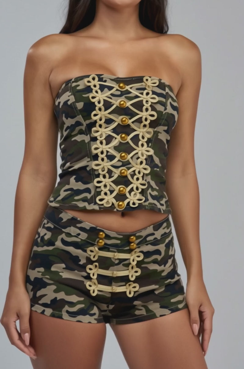 Video of a woman modeling the DRILL ME DOWN CORSET—a camo military strapless corset-style top with gold decorative buttons and trim.