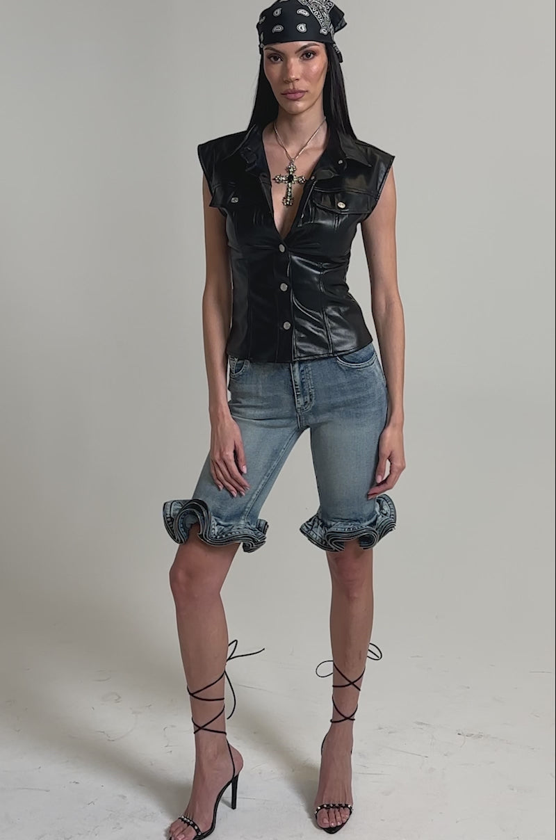 A video of a woman in a sleek GUESS WHO FAUX LEATHER BUTTON DOWN sleeveless top.