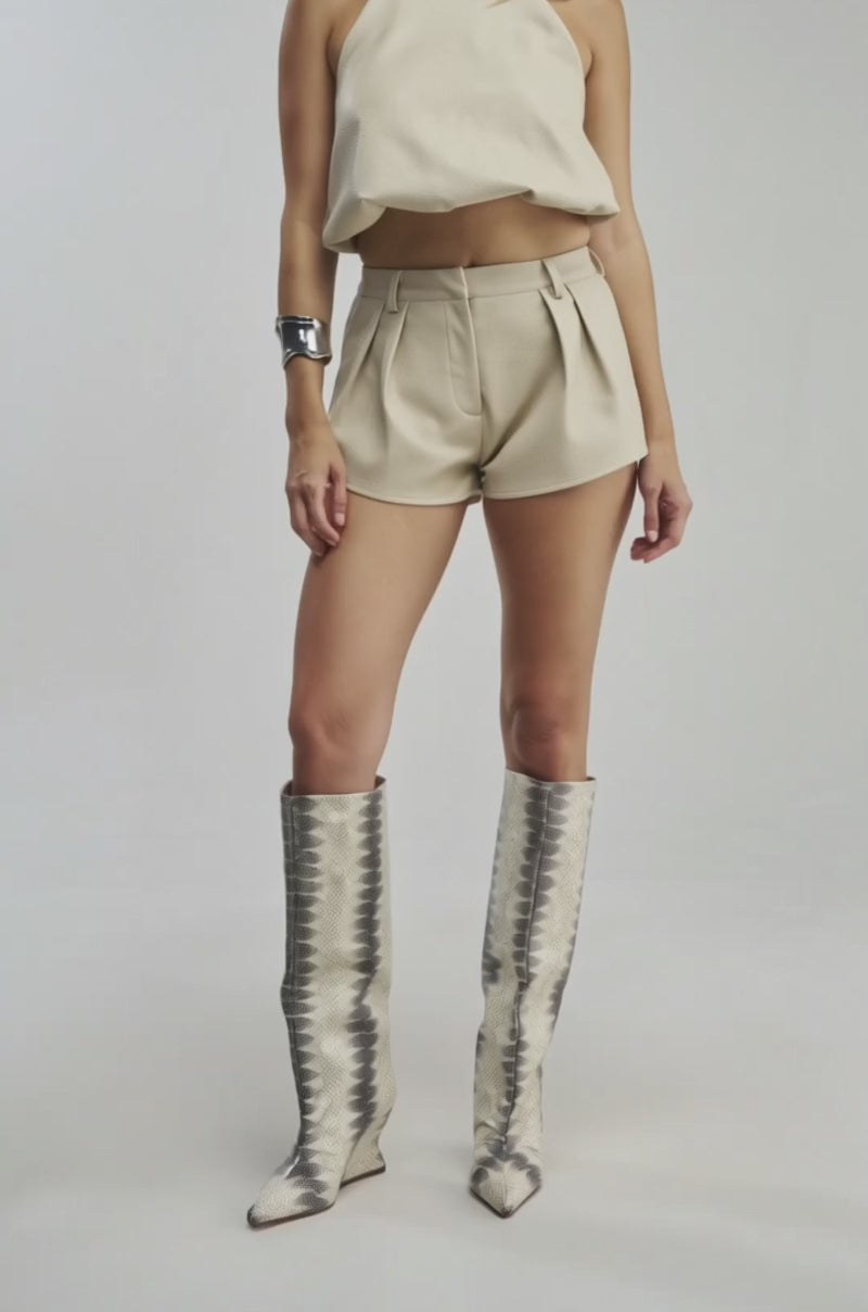 Video of a woman modeling the UBAE LEATHER SHORT in cream faux leather.