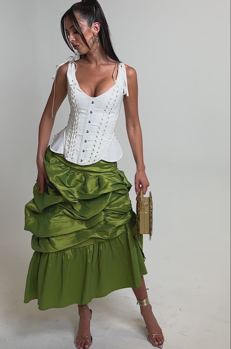 A video of a woman in the ALL OVER THE PLACE MIDI SKIRT, paired with a white corset top.