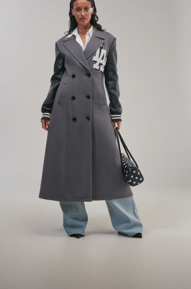 Video of a woman modeling the HIDDEN HILLS HERRINGBONE VARSITY TRENCH with striking black leather sleeves.