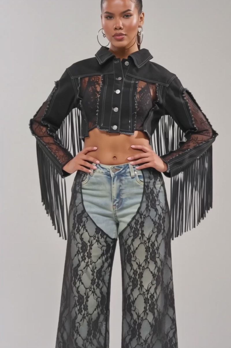 Video of woman modeling the LACED AND LOADED DENIM JACKET—a cropped black festival piece with lace panels and fringe sleeves