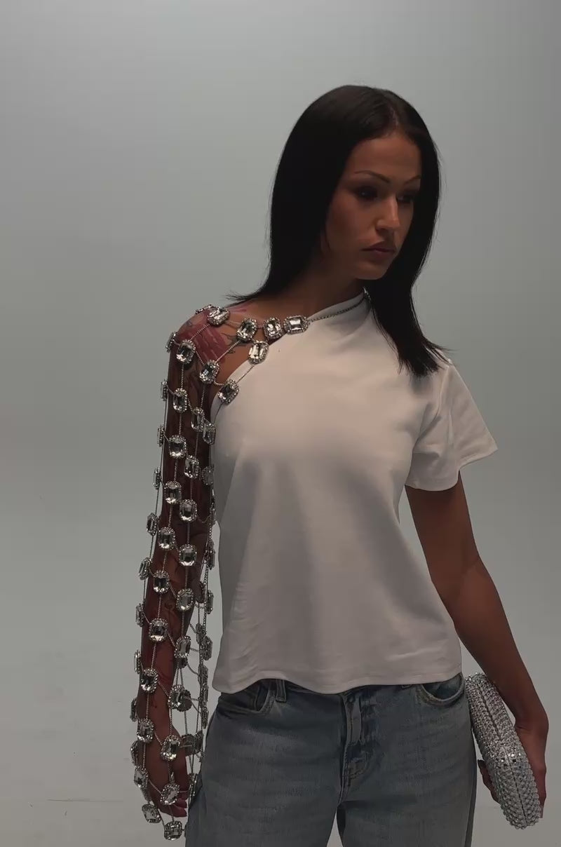Video of a woman modeling the LIFE OF THE PARTY TEE with rhinestone chain sleeves and metallic detail.