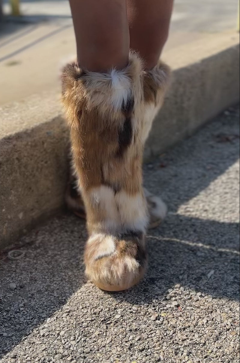 Video of woman modeling the AZALEA WANG FENNEC MULTI FUZZY FLAT KNEE HIGH BOOT in a multicolor brown, white, and black animal print faux fur.