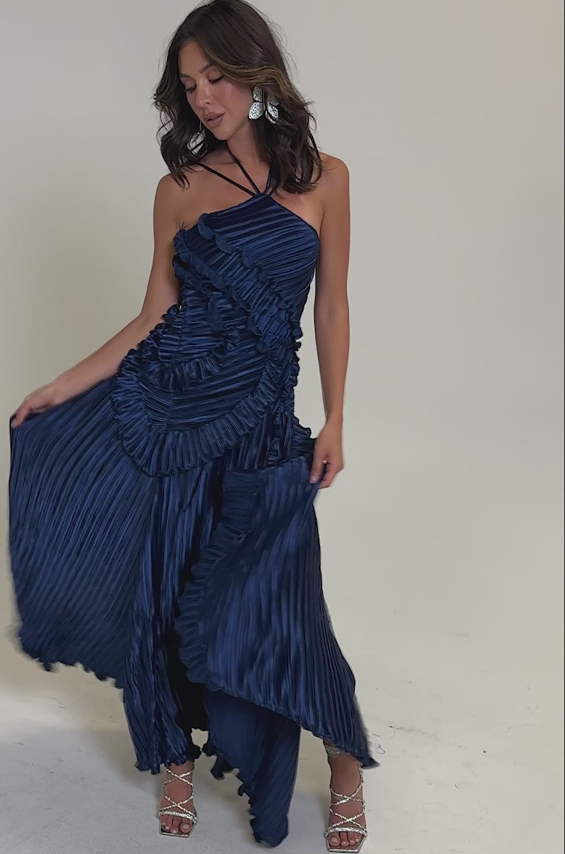 Video of woman modeling the CELESTE RUFFLE MIDI DRESS in cobalt blue, featuring pleats, ruffle details, and a halter neckline against a plain background.
