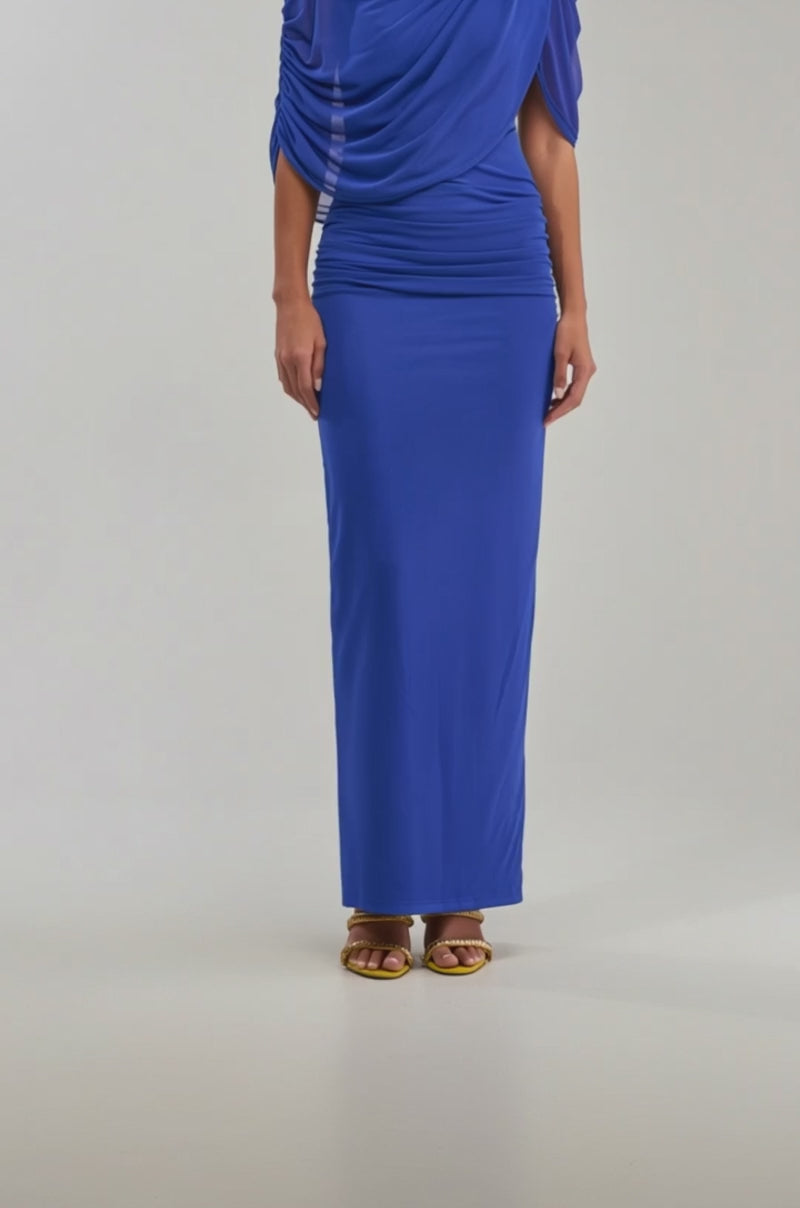 A video of a woman wearing the GODDESS MENTALITY DRAPED MAXI DRESS, a fitted royal blue maxi with draped details and short sleeves, paired with gold strappy heels.