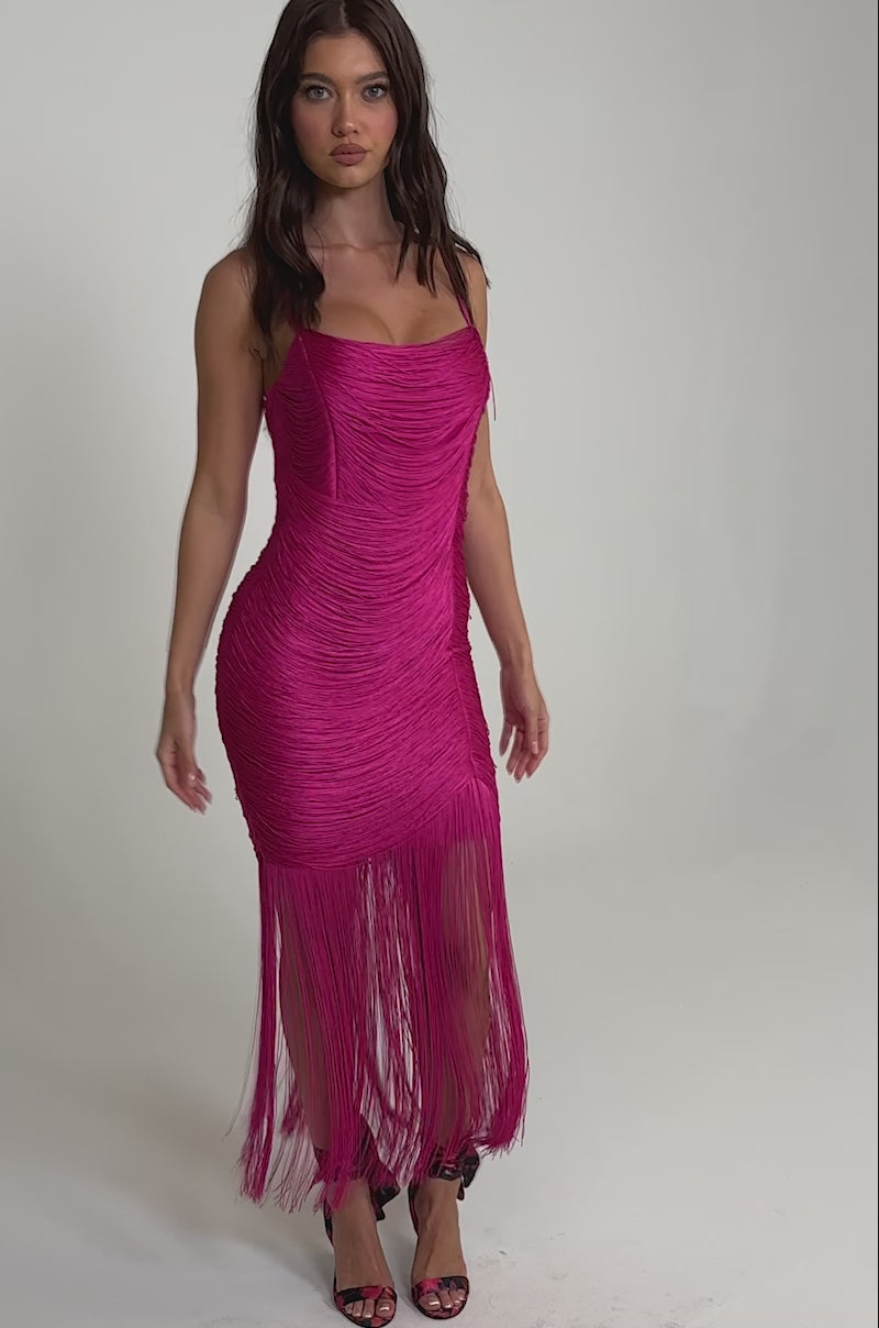 A video of a woman in the TAKE ME DANCING FRINGE MAXI DRESS IN FUSCHIA and printed heels.