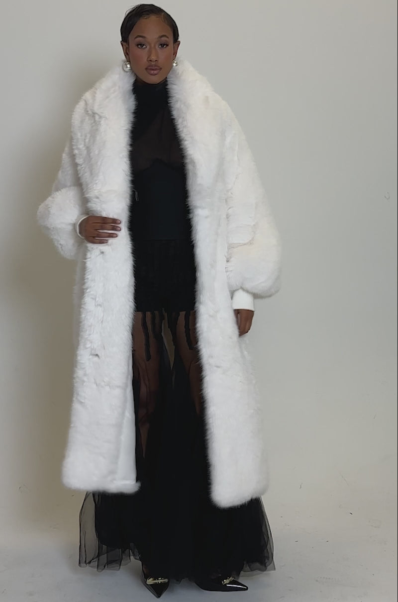 Video of woman modeling the TSUNAMI FAUX FUR COAT IN WHITE, featuring a longline silhouette and wide lapels