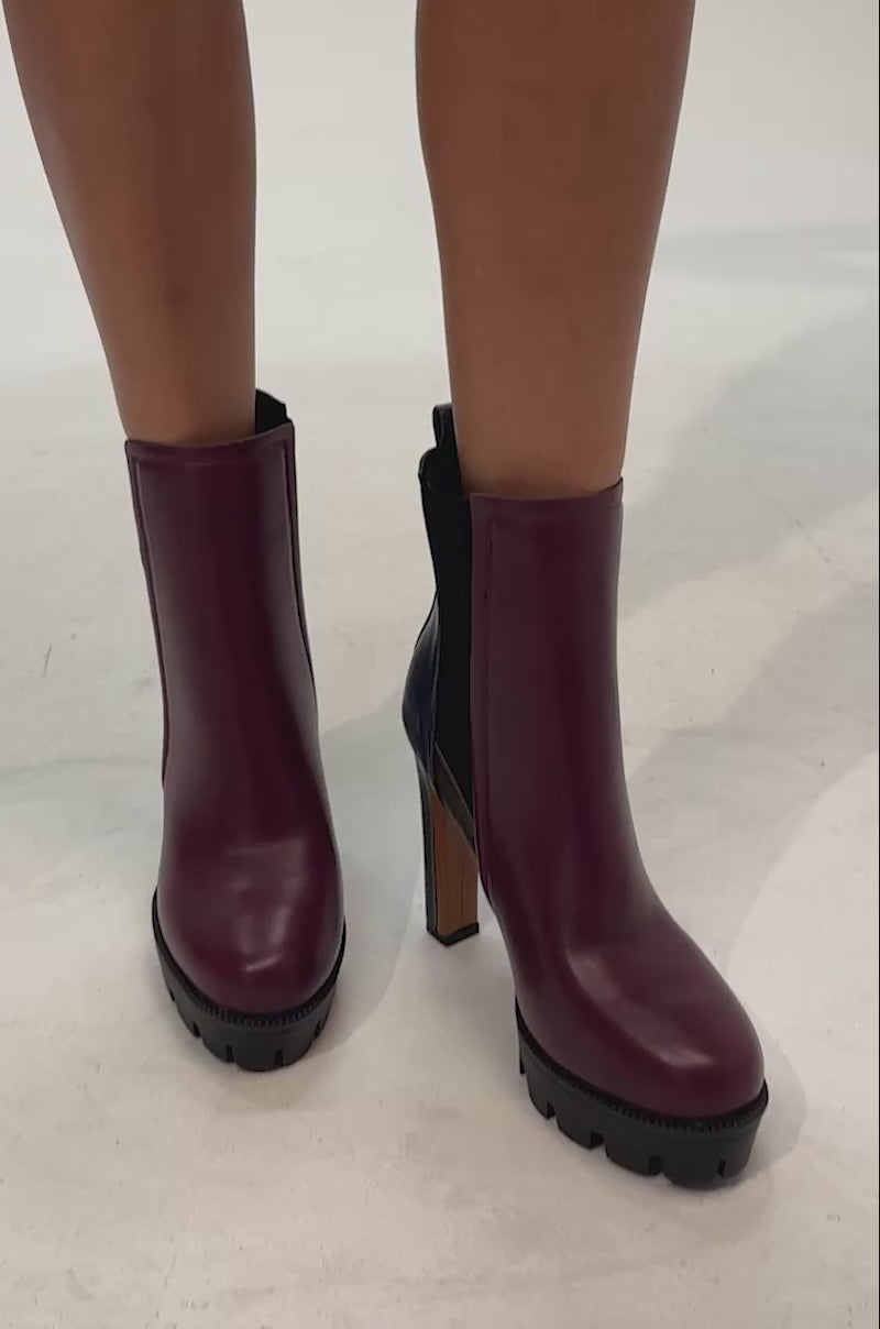 Video of woman modeling the AZALEA WANG MARO MULTI COLOR BLOCKED PLATFORM BLOCK BOOTIE—featuring burgundy and navy hues with black stretch panels and chunky lug soles