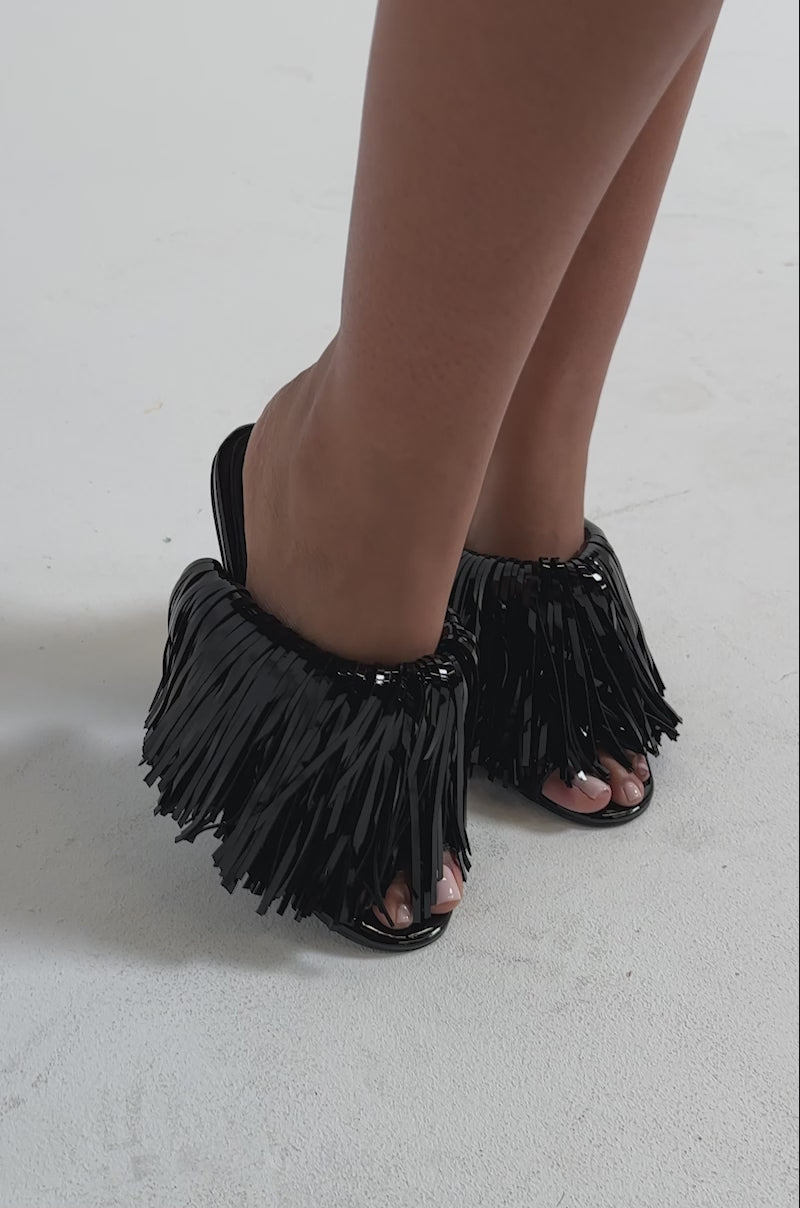 A video of a person wearing the AZALEA WANG VAILYN BLACK FRINGE PU WEDGE SANDAL.