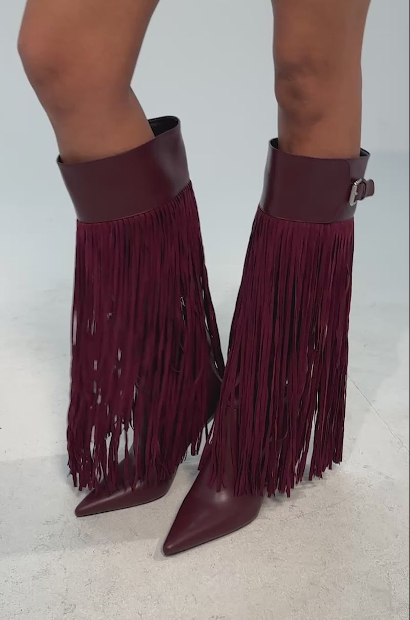 Video of woman modeling the AZALEA WANG HEARTBEAT BURGUNDY FRINGE BOOT—burgundy faux leather, knee-high stiletto with pointed toes and long fringe