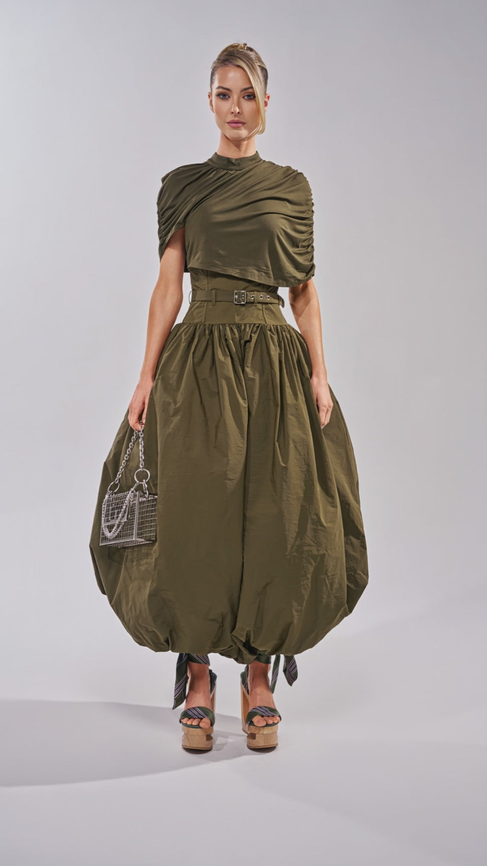 Video of woman modeling the SPIN ME AROUND POPLIN JUMPSUIT with a belted waist, ruched short sleeves, and a balloon-style pant