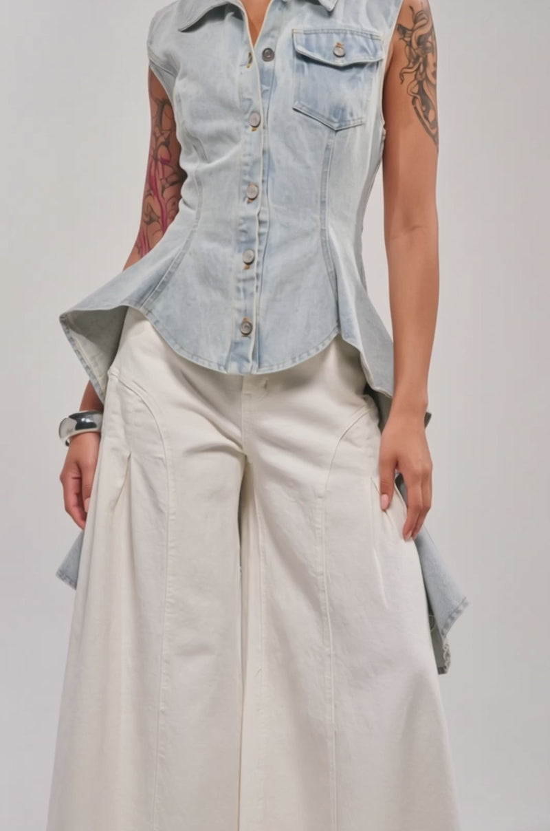 A video of a woman wearing the HIGH LOW DENIM VEST and wide-leg, high-waisted white pants. 