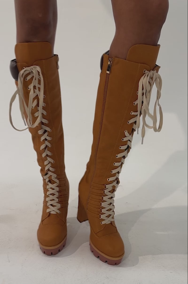 Video of a woman modeling the AKIRA GOLD MIRETH TAN BLOCK KNEE HIGH BOOTS, standing against a plain background.