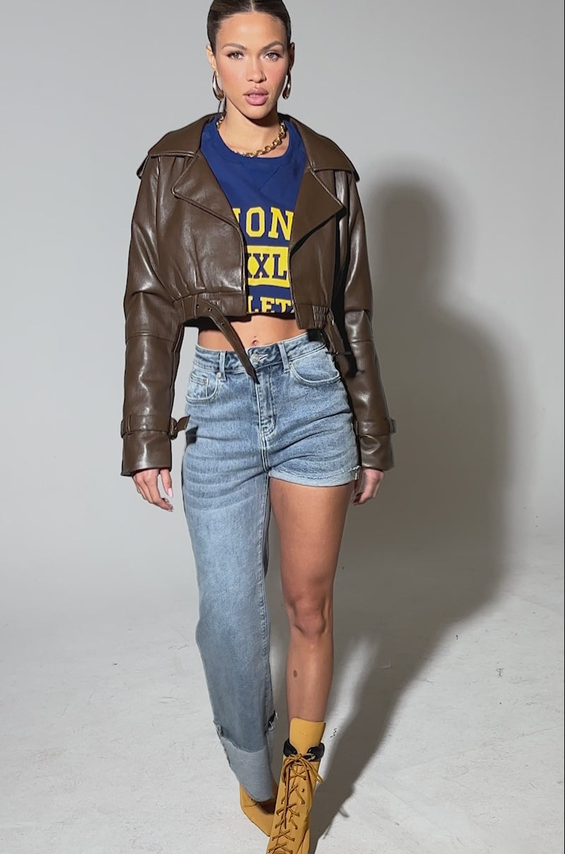 Video of woman modeling the BUTTER LUXE MOTO IN CHOCOLATE jacket over a blue and yellow "LIONS XXL ATHLETICS" T-shirt 