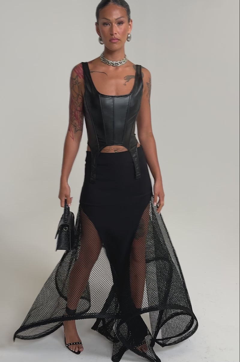 A video of a woman wearing the FREE IN MOTION MAXI SKIRT paired with a black leather corset top, small black handbag, and high heels.