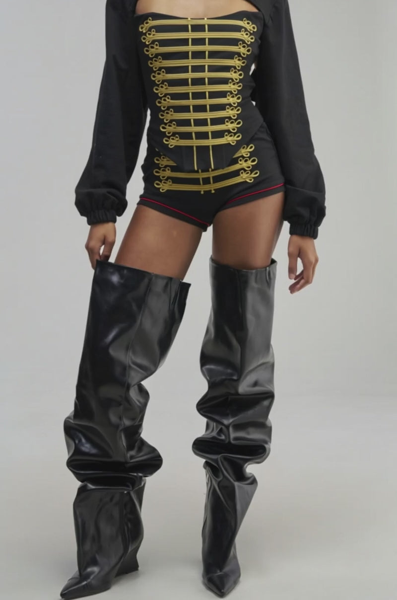 Video of a woman modeling the HAUTE COMMAND CORSET—a black military-inspired corset adorned with gold trim.