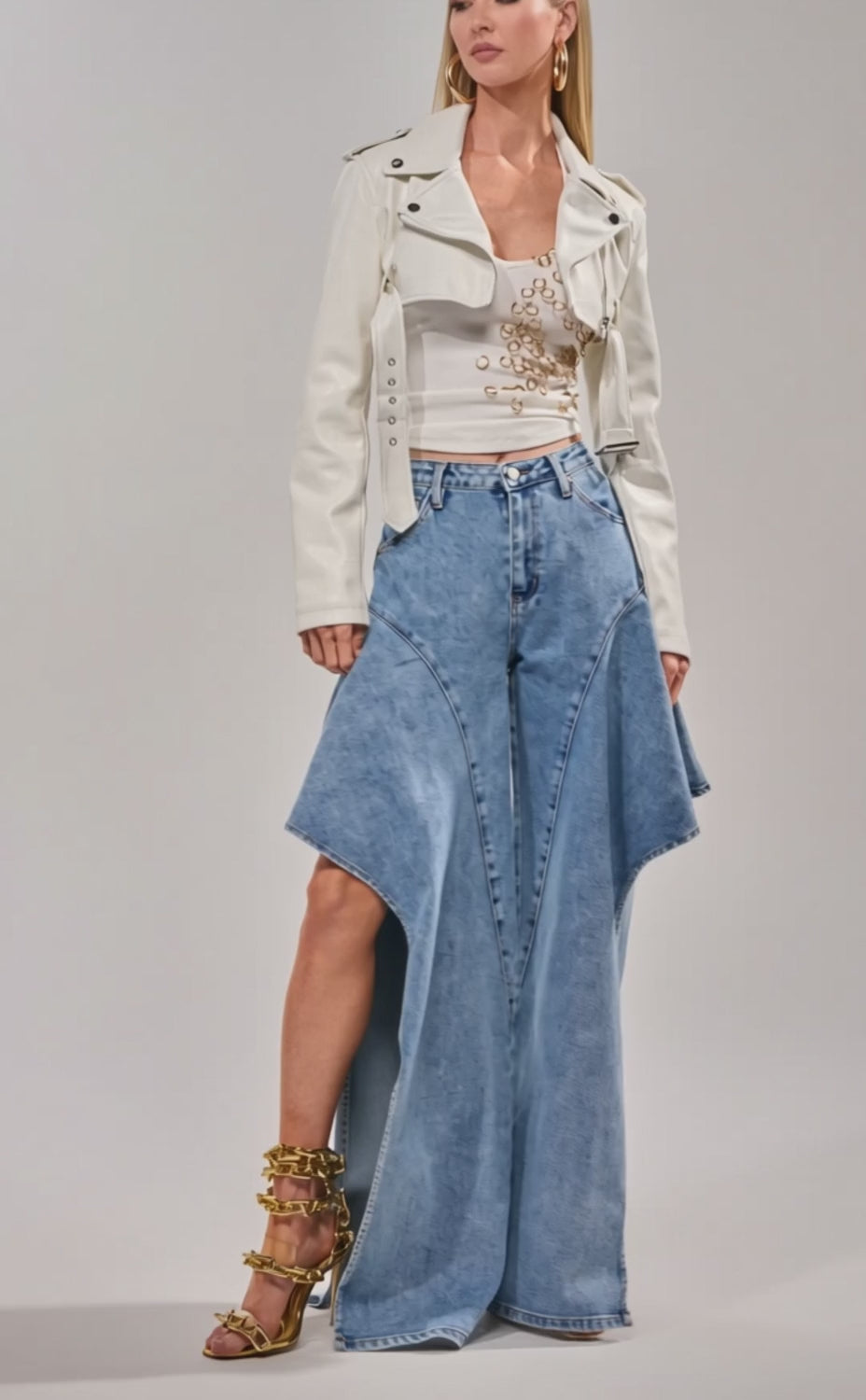 Video of woman modeling the HARLEY LUXE ULTRA CROP MOTO IN WHITE over a beaded white top and wide-leg blue jeans.