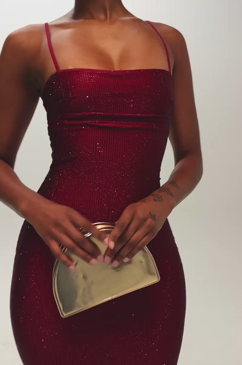 Video of a woman modeling the SOCIAL ROYALTY RHINESTONE MAXI DRESS IN BURGUNDY—a form-fitting, sleeveless, floor-length maxi dress with thin straps and sparkling rhinestone details.